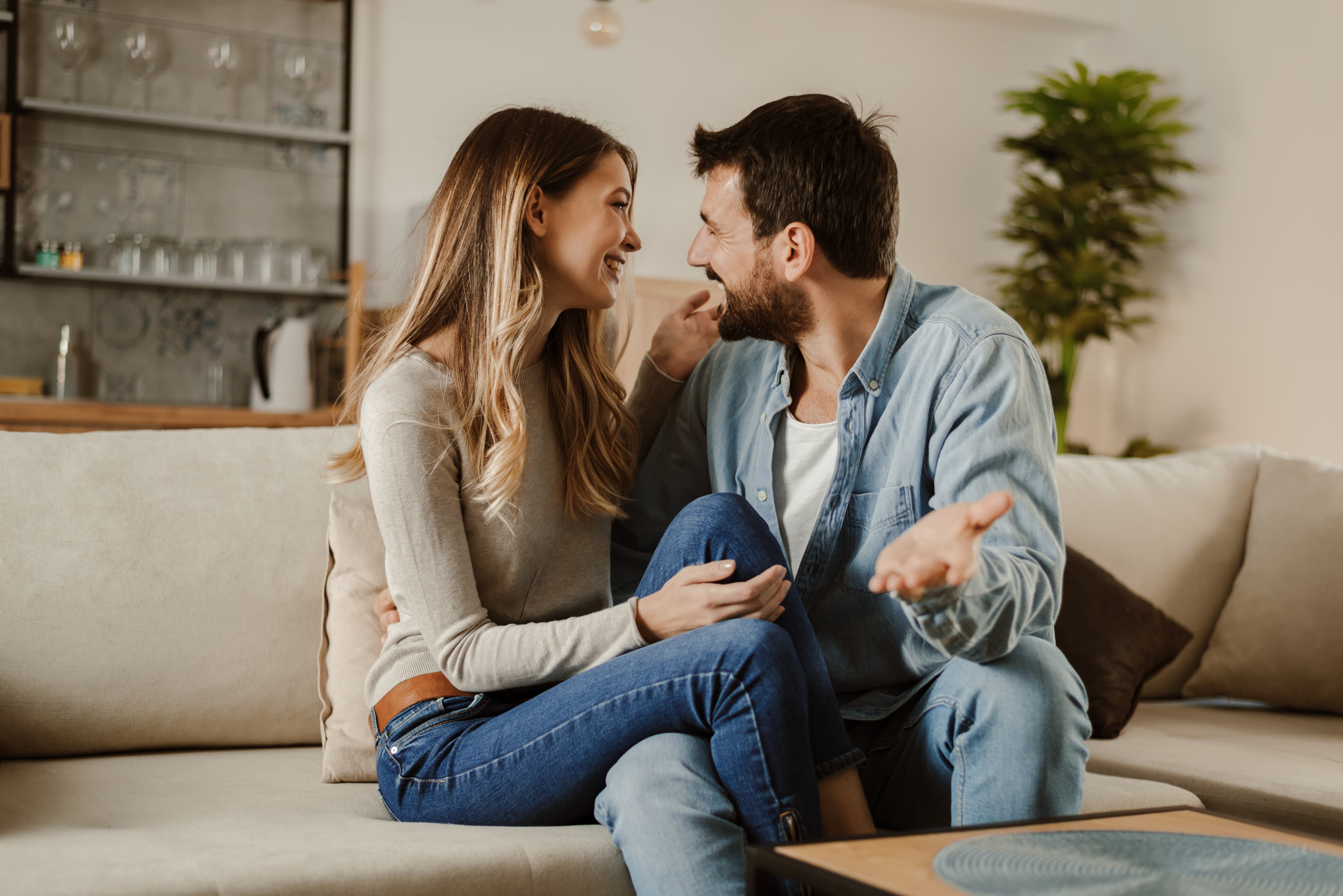 A couple smiling and talking together at home.
